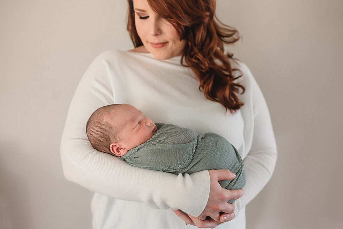 mother hold newborn baby boy for newborn portraits in memphis tn