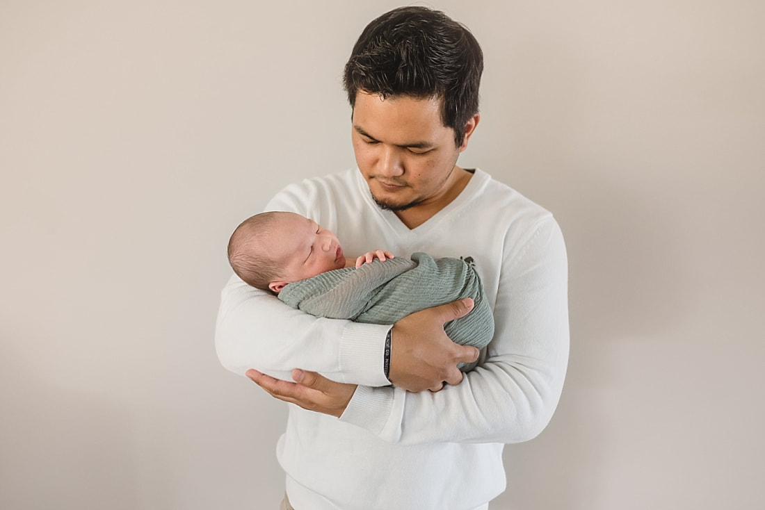 father holding newborn baby boy for newborn portraits in memphis tn