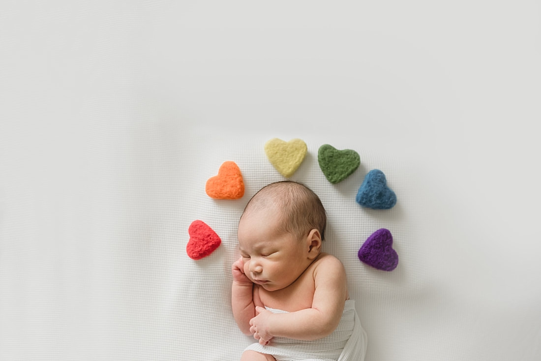 rainbow baby photo, newborn baby boy wrapped in white with rainbow hearts for newborn photo shoot in memphis tn