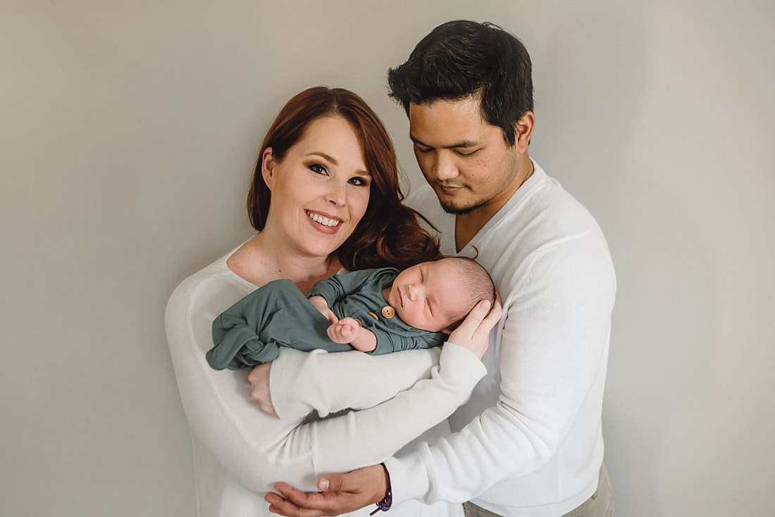 new family of three, mom and dad holding newborn baby boy during newborn photos in memphis, tn