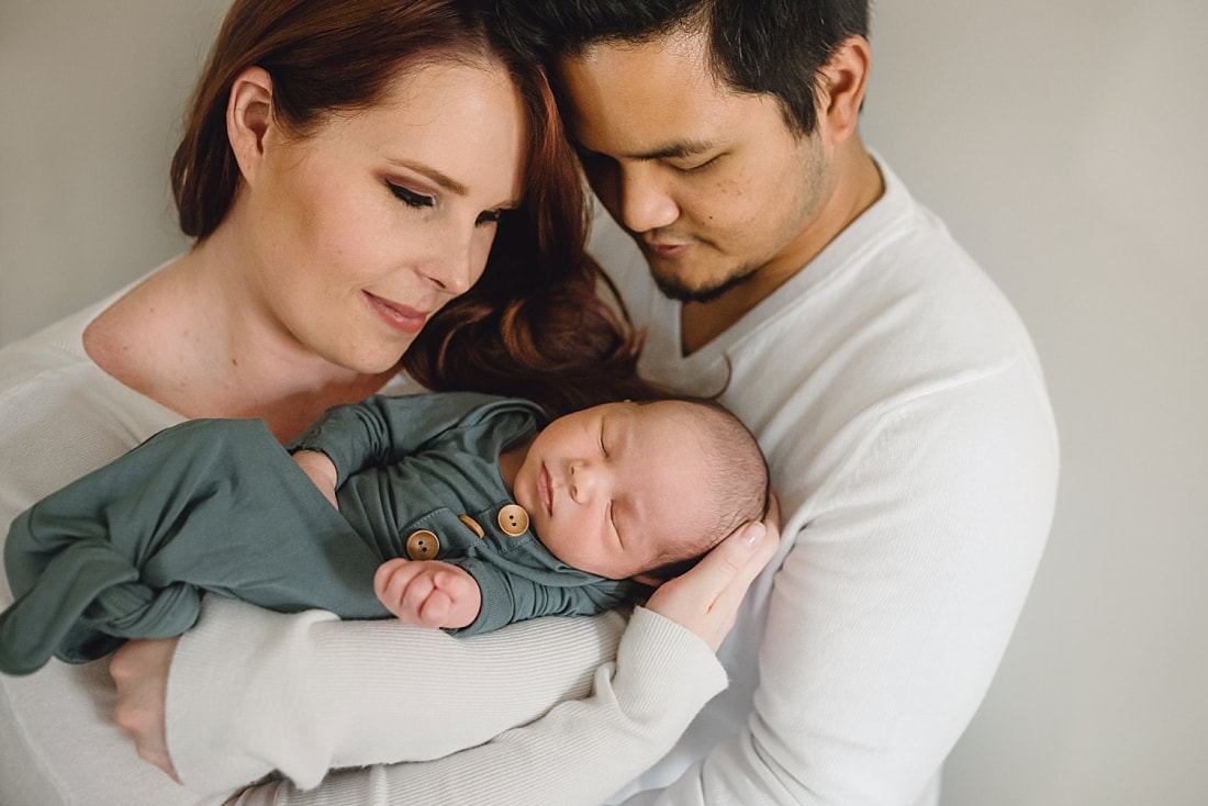 new family of three, mom and dad holding newborn baby boy during newborn photos in memphis, tn