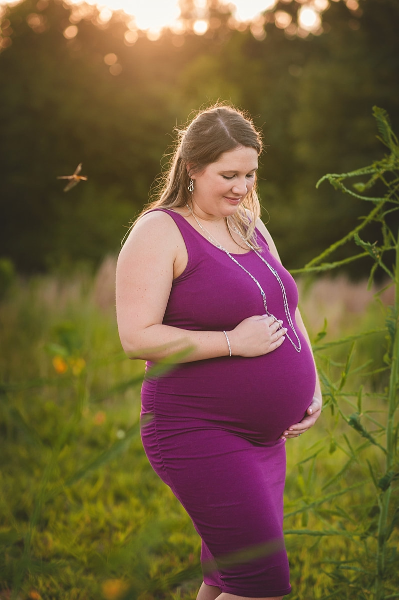 pregnant mother being visited by a dragonfly during maternity photo session at Shelby farms park