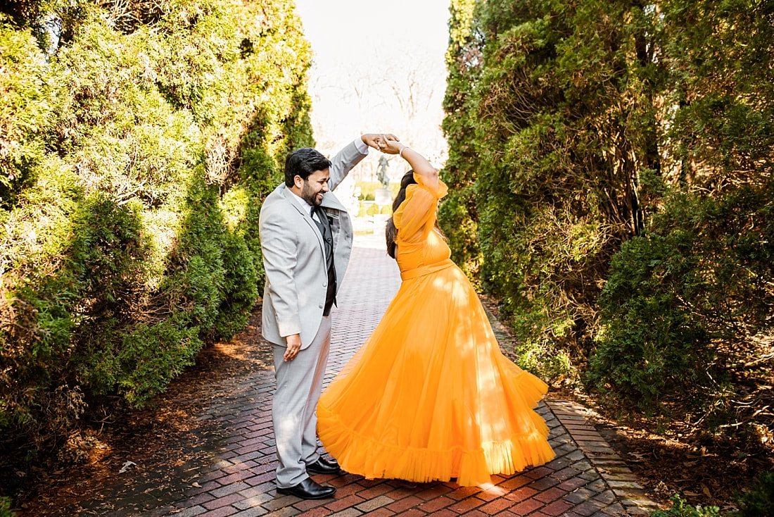 mother and father dancing during maternity photo session at memphis botanic garden