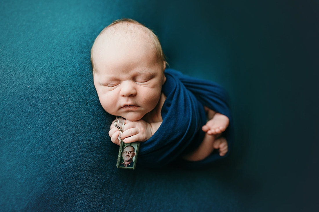 Newborn baby boy swaddled in blue blanket for newborn portrait in Memphis, TN