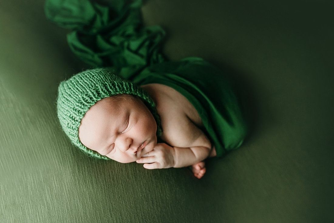 newborn baby boy posed and sleeping on green blanket in Memphis, TN