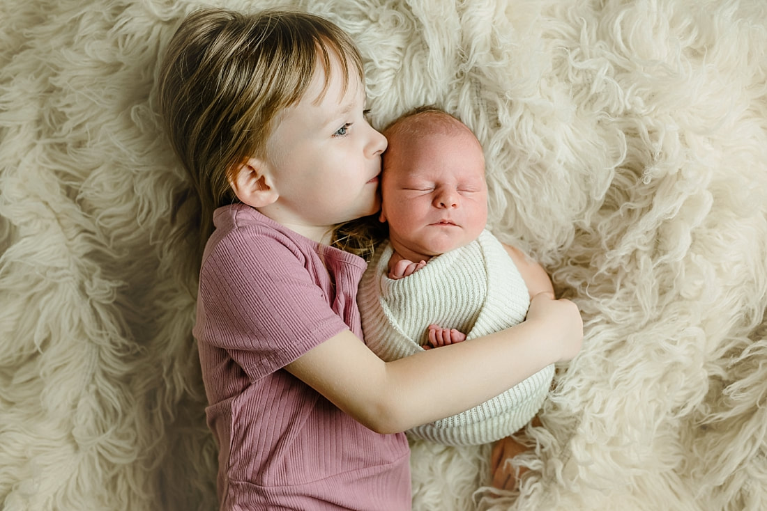 big sister holding newborn baby brother in Memphis, TN