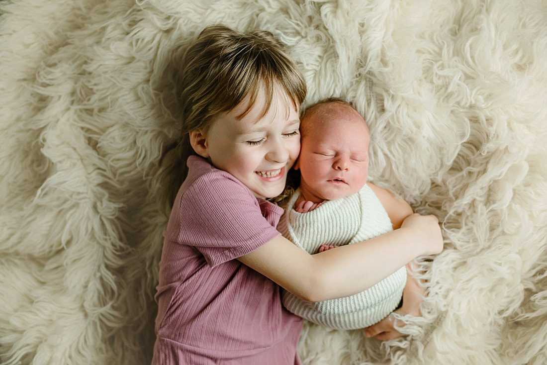 big sister holding newborn baby brother in Memphis, TN