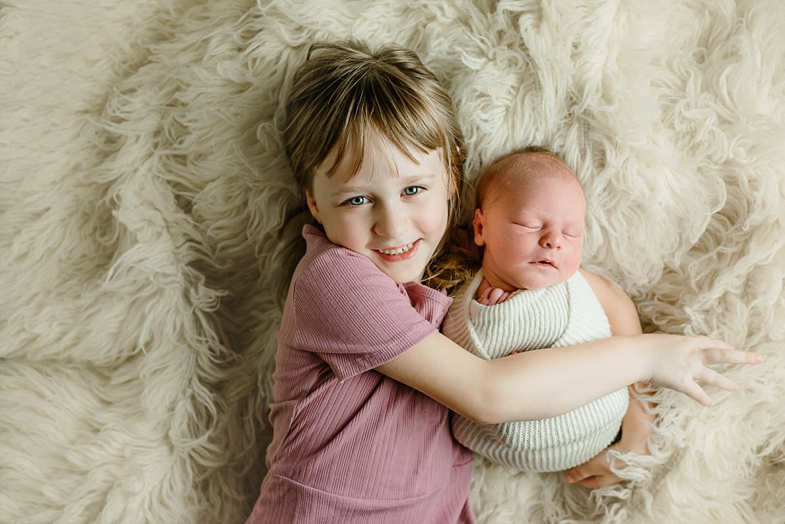 big sister holding newborn baby brother in Memphis, TN